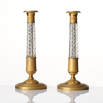 A pair of French gilt bronze and cut-glass Empire-style candlesticks, later part of the 19th century.