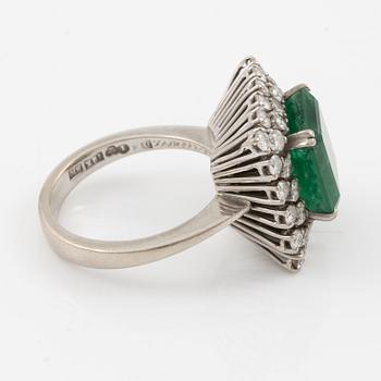 Ring in 18K white gold set with a faceted emerald and round brilliant-cut diamonds.