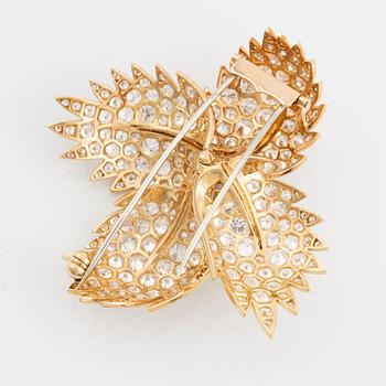 A Van Cleef & Arpels flower brooch in 18K gold set with round brilliant-cut diamonds.