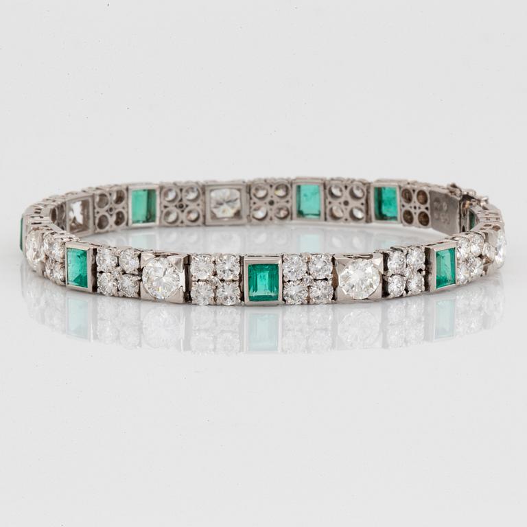 A platinum bracelet set with round brilliant- and old-cut diamonds and faceted emeralds.
