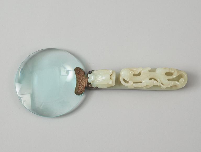 A Chinese archaistic nephrite belt hook, mounted as a magnifying glass.