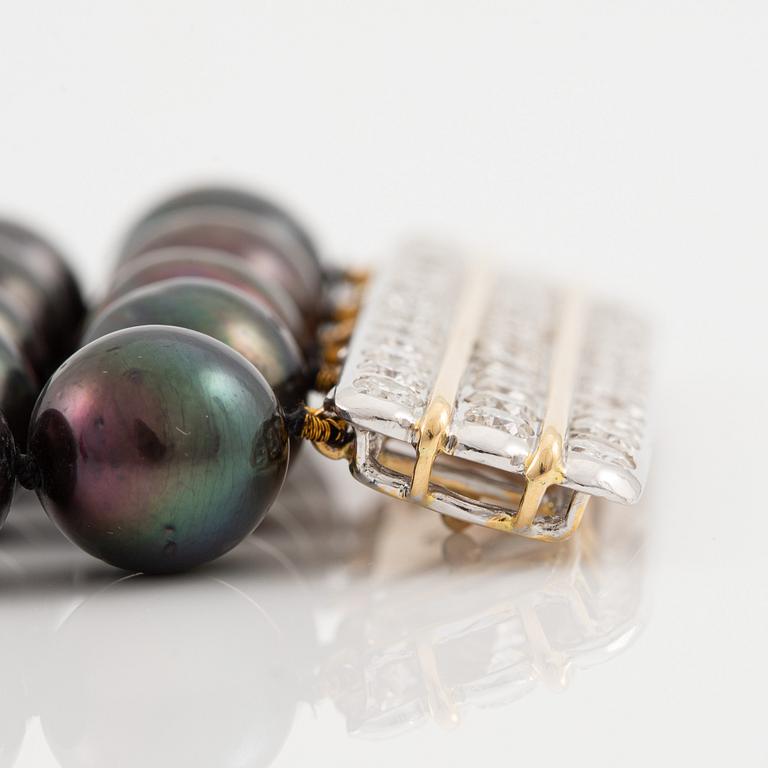 Bracelet with five rows of cultured black pearls, clasp in 18K gold and white gold set with brilliant-cut diamonds.