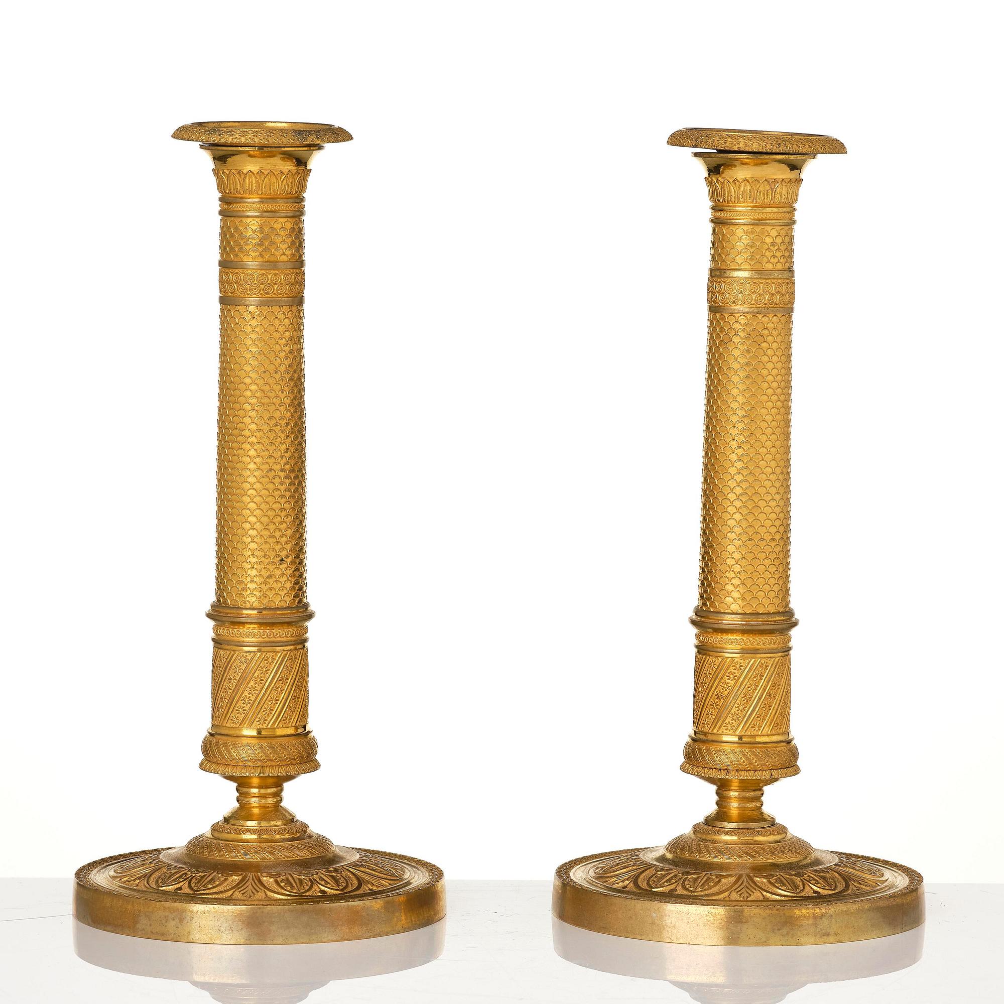 A pair of French Empire ormolu candlesticks, early 19th century.