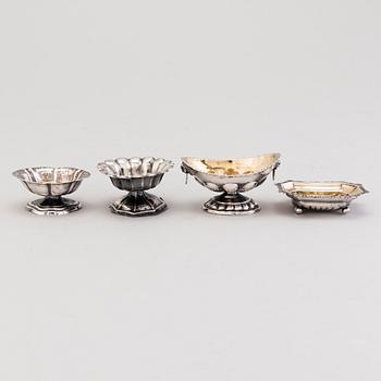 Four Russian 19th Century silver salt cellars and four Finnish 1920s parcel-gilt salt spoons.