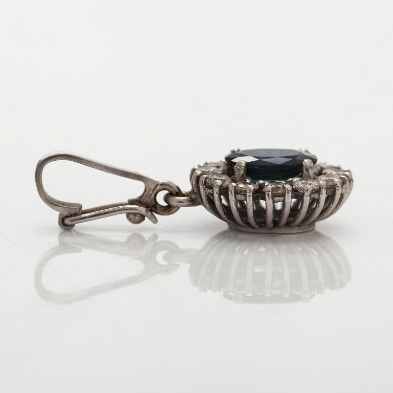 An 18K white gold pendant with sapphire and diamonds.
