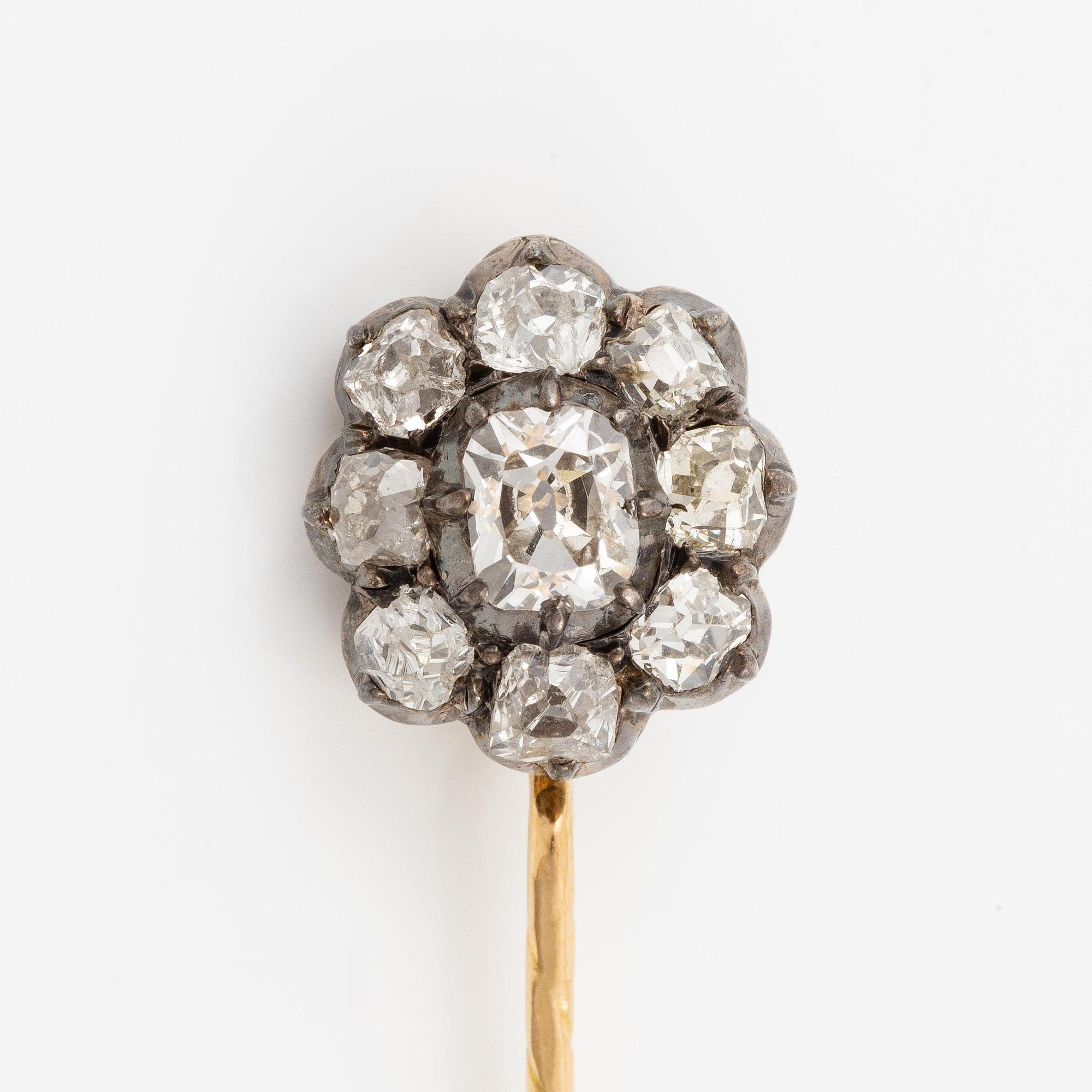 A brooch/pin in 18K gold silver with old-cut diamonds.