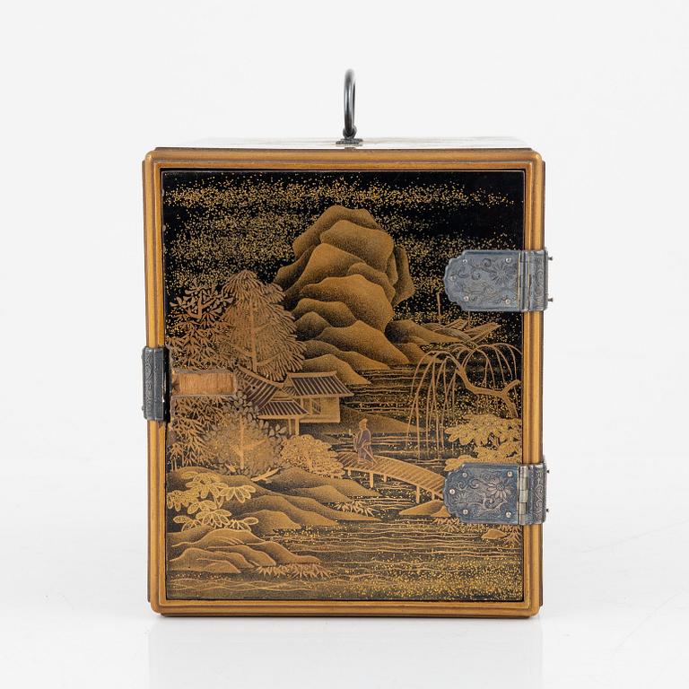 A Japanese lacquer cabinet with tree drawers behind the door, early 20th Century.