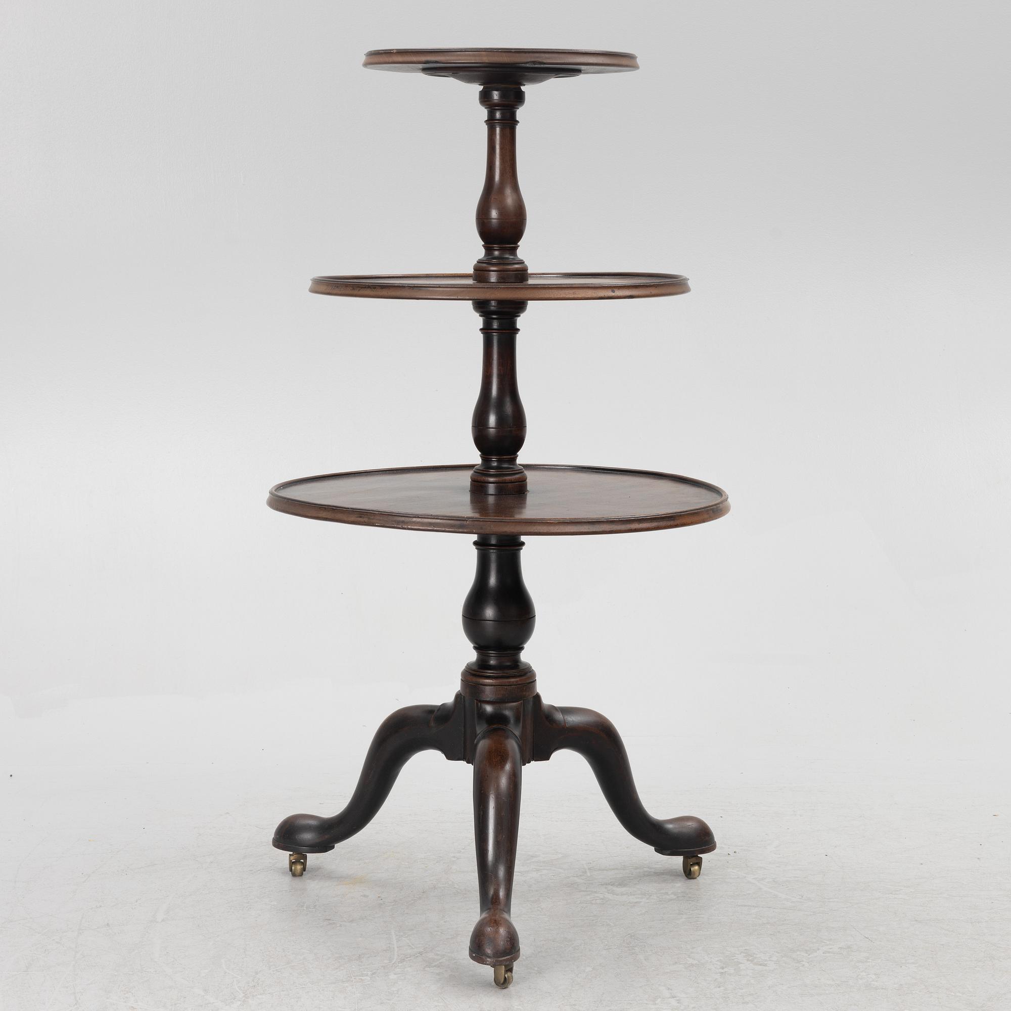 A mahogany three-tier table, England, circa 1900.
