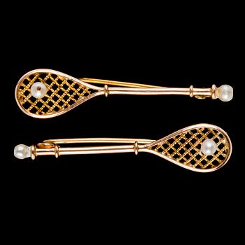 874. A pair of tennis rack brooches, early 20th century.