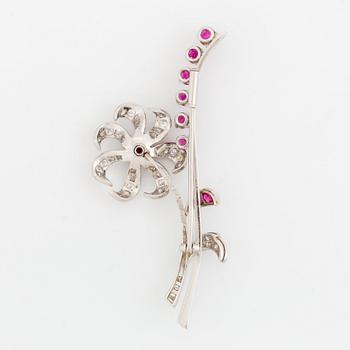 A flower brooch in platinum set with faceted rubies and round brilliant- and eight-cut diamonds.