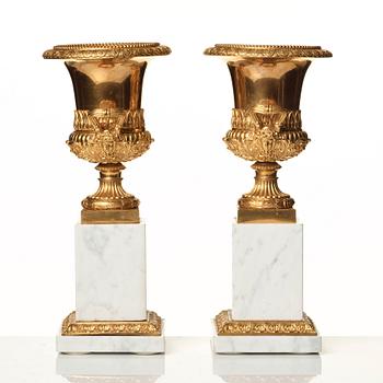 A pair of French 19th century gilded urns.