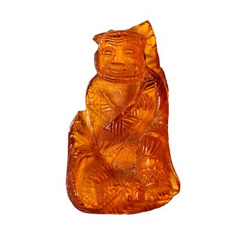 135. An amber pendant in the shape of a seated man, Qing dynasty (1644-1912).