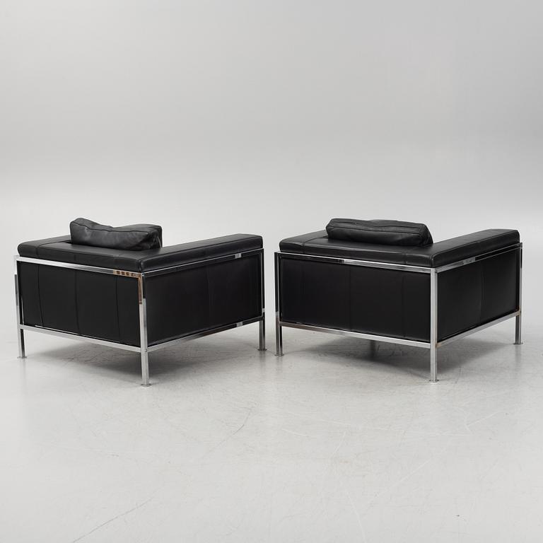 A pair of leather upholstered lounge chairs,