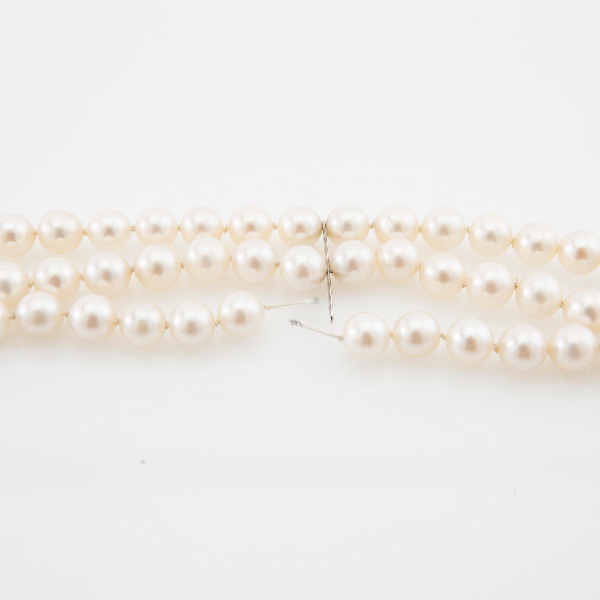 Armband treradigt av odlade pärlor med lås av 18K vitguld.