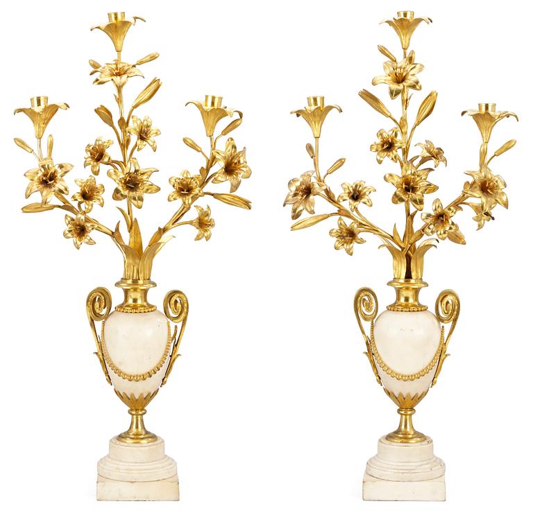 A pair of Louis XVI-style 19th century three-light candelabra.