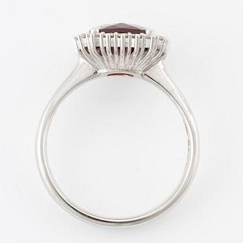 Ring in 18K gold with a faceted garnet and round brilliant-cut diamonds.