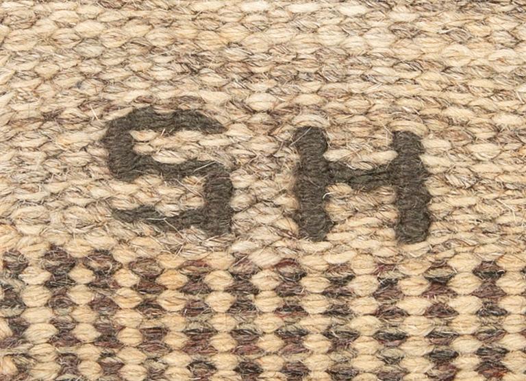A Swedish flat weave carpet signed SH ca 243 x 162 cm.