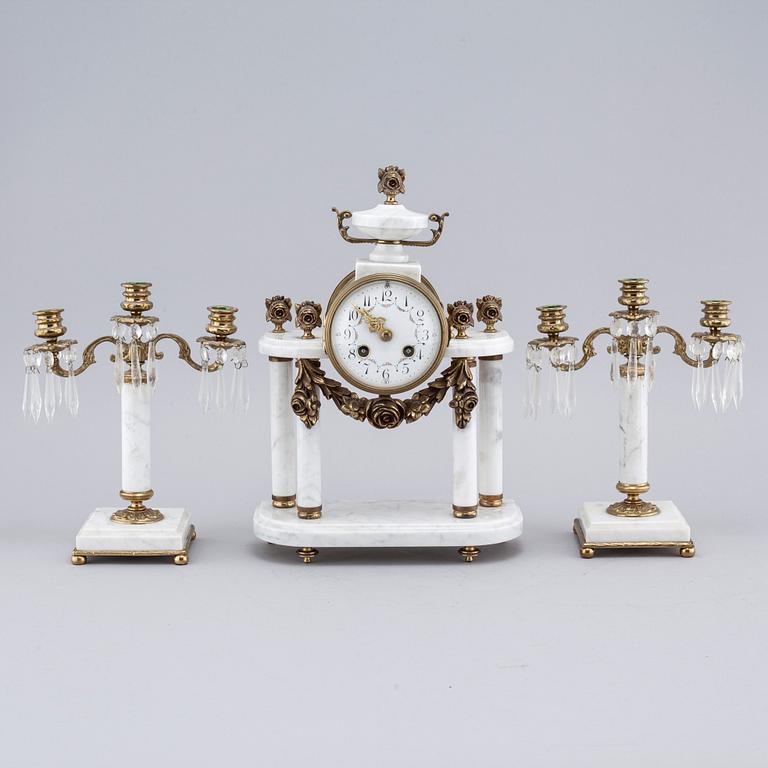 A French mantlepiece clock and a pair of candelabras, first half of the 20th century.