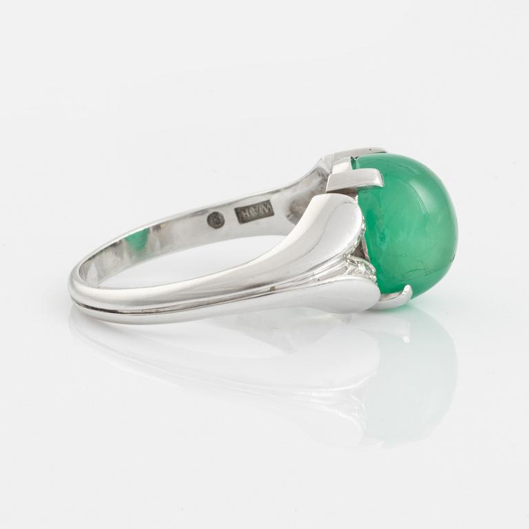 An 18K white gold ring set with a cabochon-cut emerald and eight-cut diamonds.