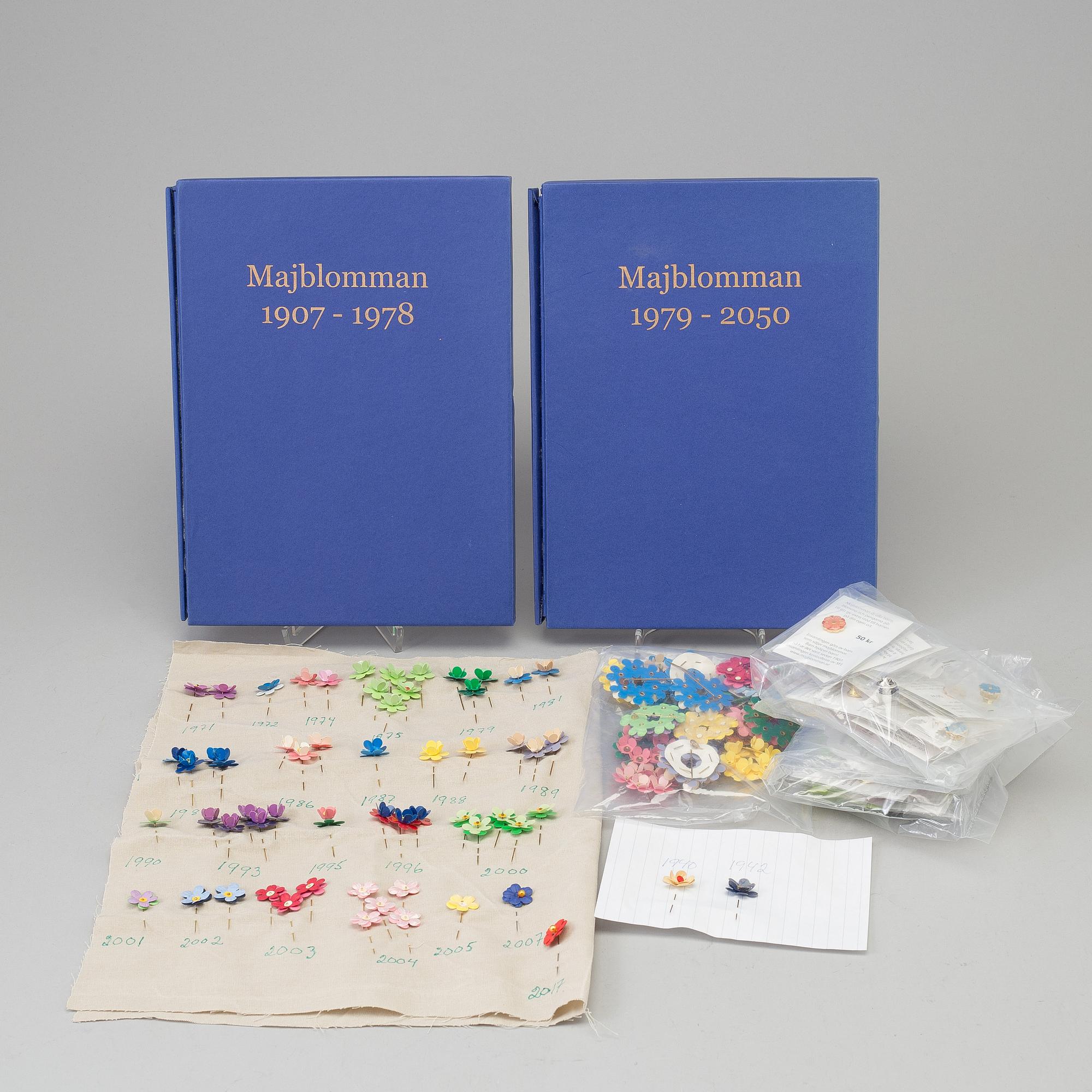 A collection of Swedish "Majblomman" brooches from between the years 1915-2016.