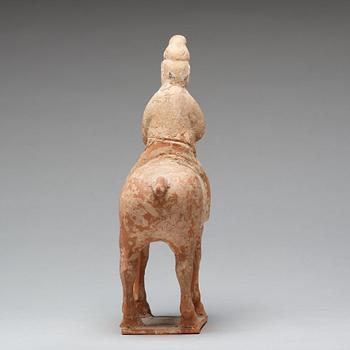 A painted pottery figure of an equestrian standard-bearer, Tang dynasty (618-907 AD.).
