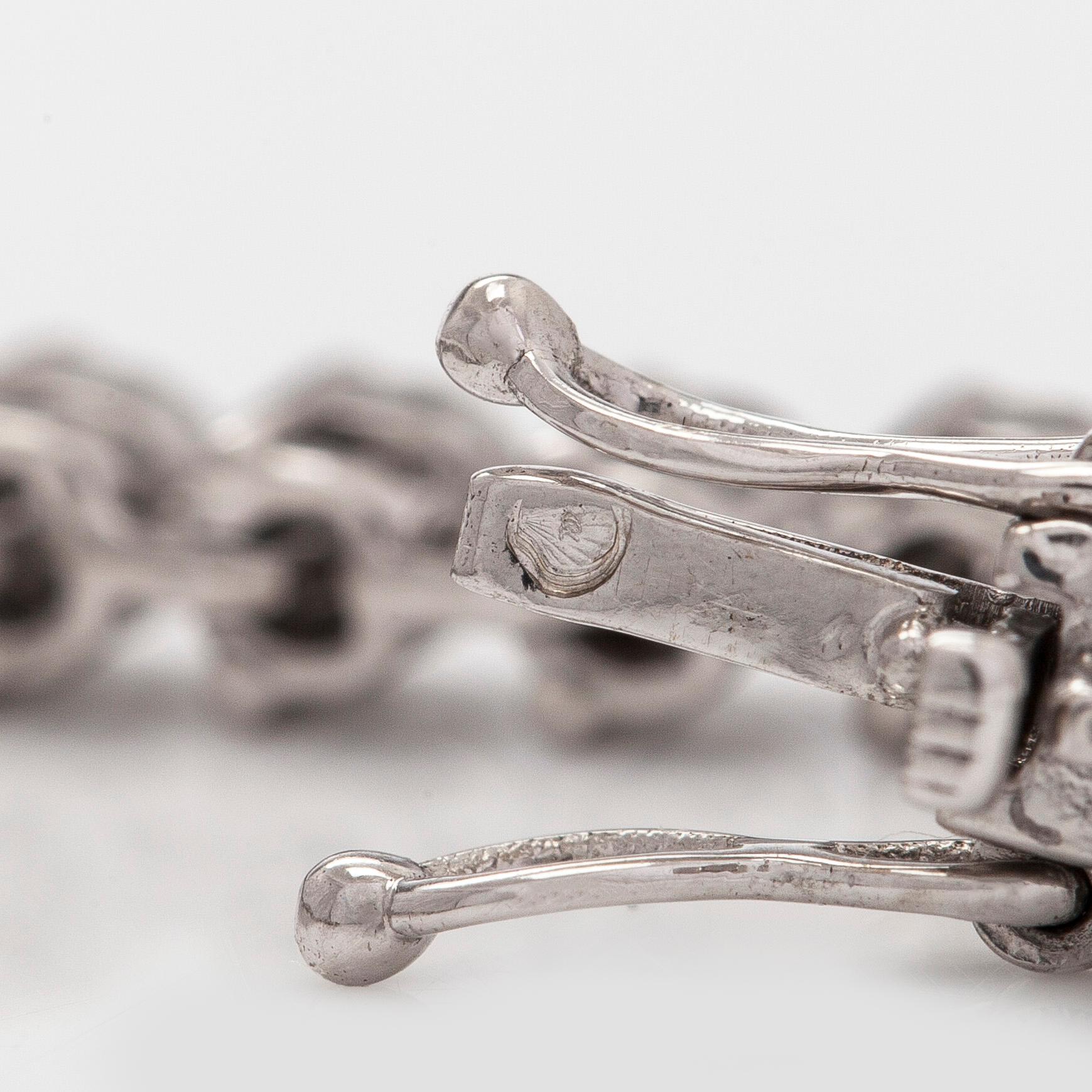 An 18K white gold tennis bracelet, with brilliant-cut diamonds.