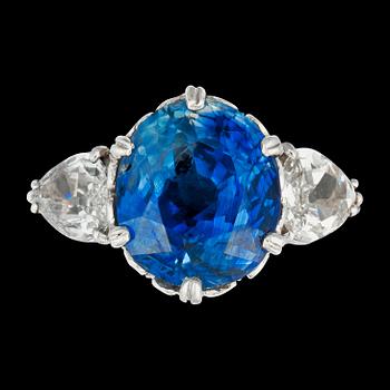 920. An untreated Ceylon sapphire, 8.14 cts, flanked by two pear shaped diamonds, ring.