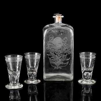 A glass bottle and three vodka glasses, 19th Century.