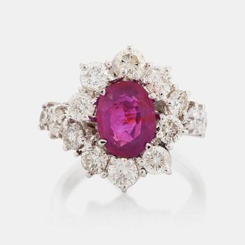 494. An 18K white gold ring set with a ruby and round brilliant-cut diamonds.