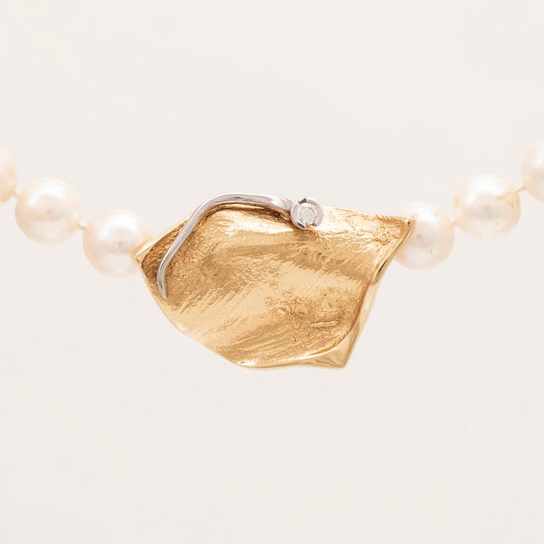 A necklace of cultured pearls, lock in 18K white and red gold set with a round brilliant cut diamond by Ole Lynggaard.