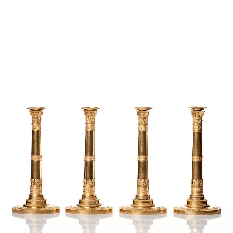 A set of four Empire presumably Russian candlesticks in gilded bronze.