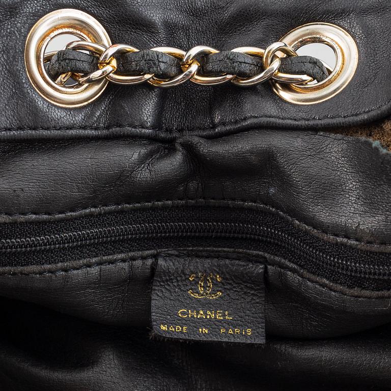 Chanel, a black leather drawstring bag.