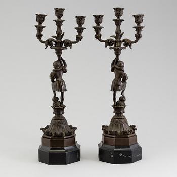 A pair of late 19th century patinated brass candelabra.