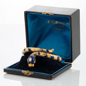An 18K gold snake bangle decorated with blue enamel and set with an opal and a rose-cut diamond.