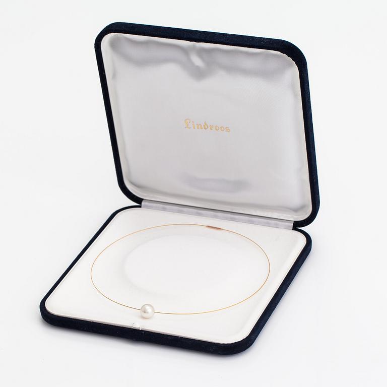A necklace with a cultured pearl and metal wire.