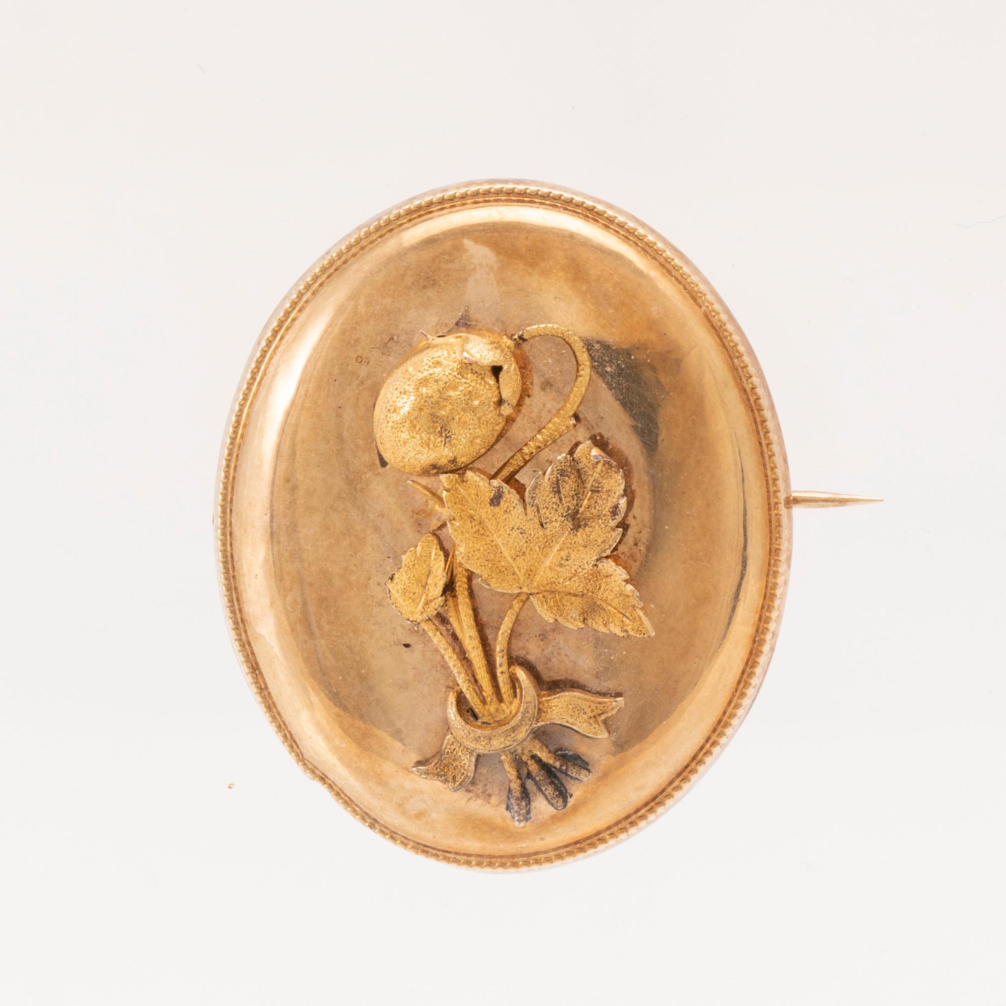 A 14K gold brooch.