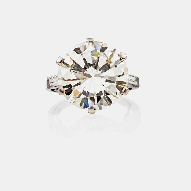 RING med briljantslipad diamant ca 8.87 ct. Kvalitet ca M-O (Cape)/VVS1. Flankerad av två baguetteslipade diamanter.