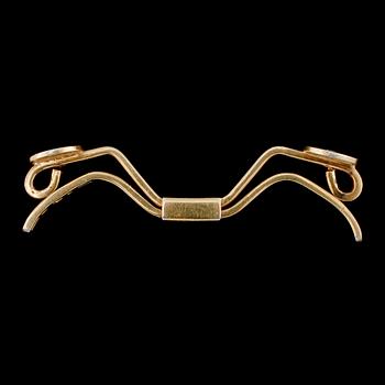 SPÄNNE, 18k guld med 2 briljantslipade diamanter, Nils Ahlström, Borås, 1953. Vikt 6 g.