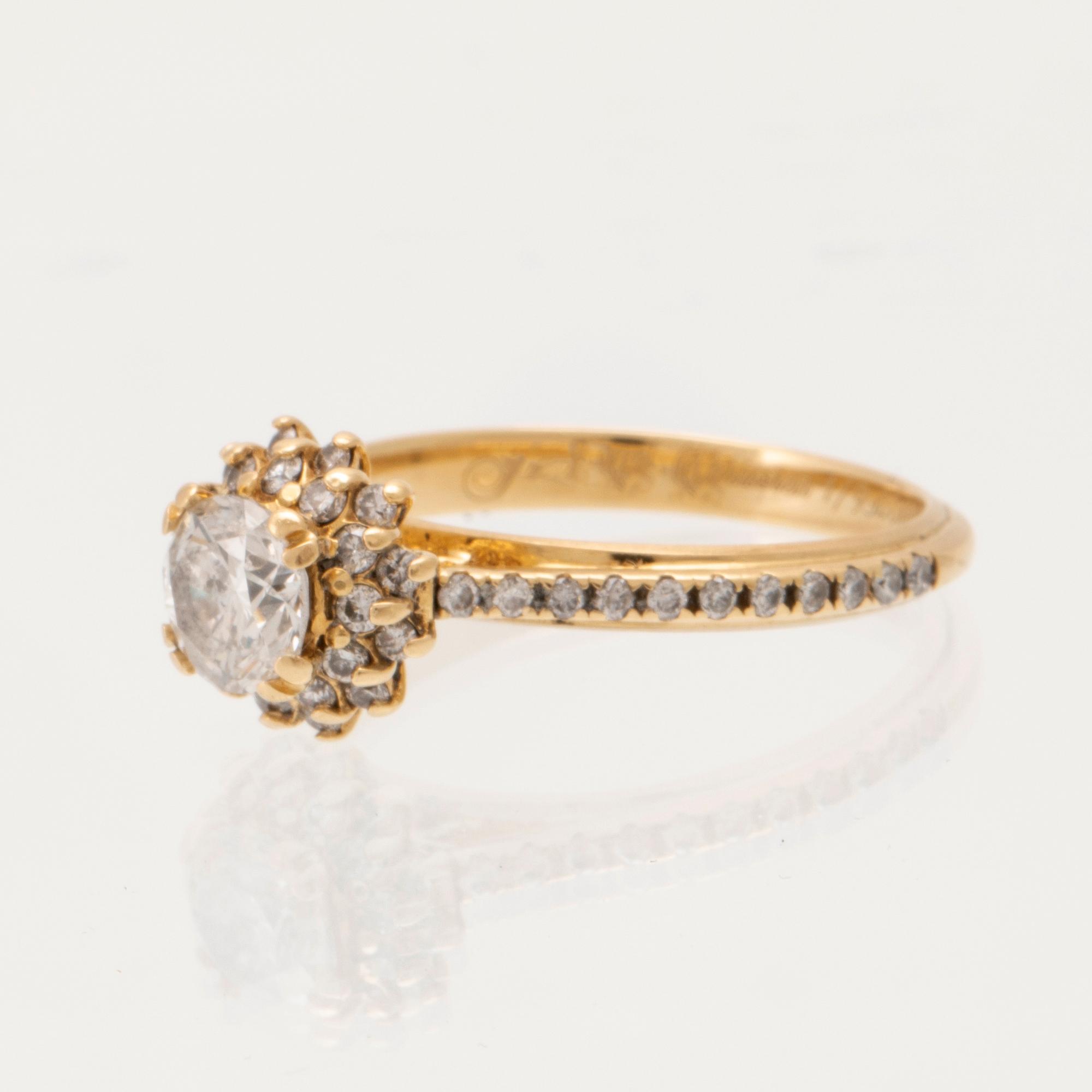 An 18K gold ring set with round brilliant-cut diamonds.