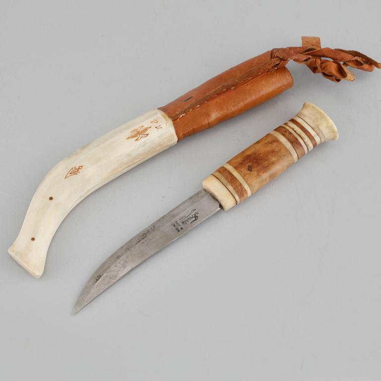 A Sami knife in antler, birch and leather, signed PU, carved dating 1975.