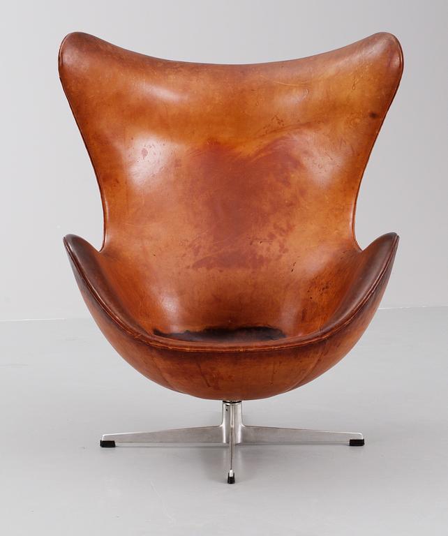 An Arne Jacobsen brown leather 'Egg chair' with ottoman, by Fritz Hansen, Denmark 1963.