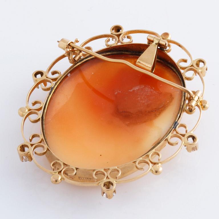 A cameo and white gemstone brooch.