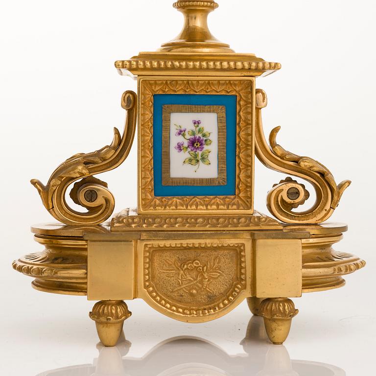 A mid-19th-century French gilt-brass mantel clock with a pair of candelabra by Dussault.