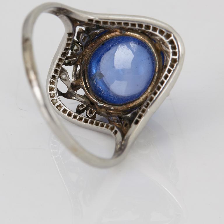 A RING set with a cabochon-cut sapphire.