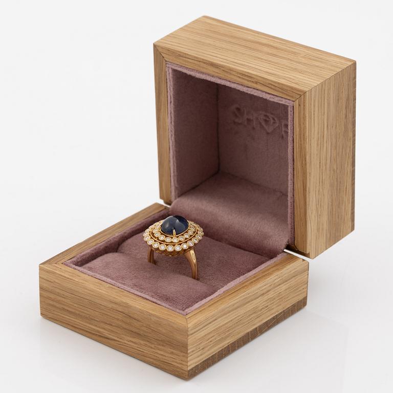 Ring in 18K gold set with a cabochon-cut sapphire and brilliant-cut diamonds.