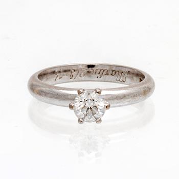 An 18K white gold solitaire ring set with a round brilliant cut diamond by Kaplans, with GIA dossier.