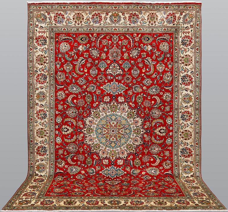 A signed Tabriz carpet, ca 336 x 223 cm.