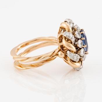 An 18K gold  ring with a sapphire and round brilliant-cut diamonds.
