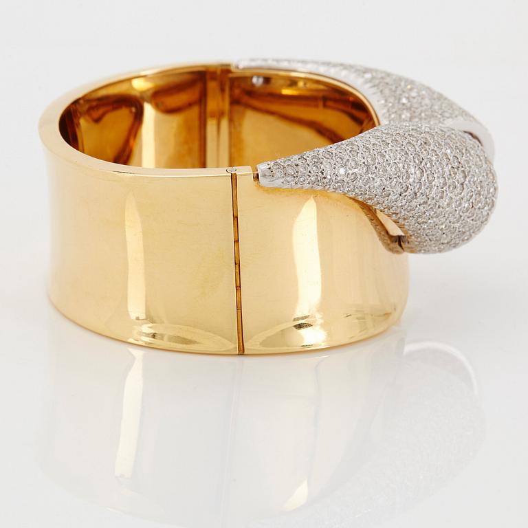 An 18K gold bangle set with round brilliant-cut diamonds.