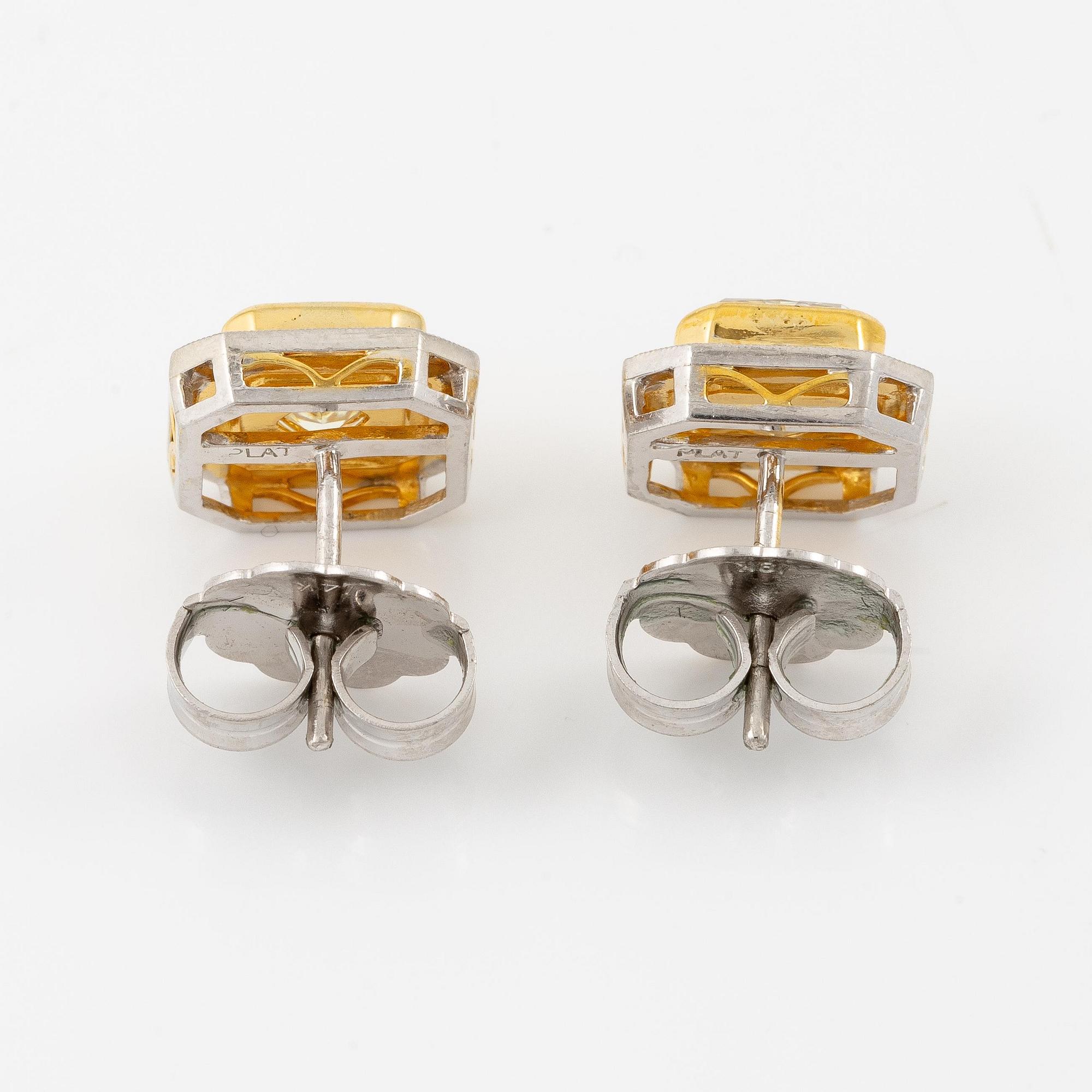 A pair of platinum and gold earrings with two radiant-cut yellow diamonds.
